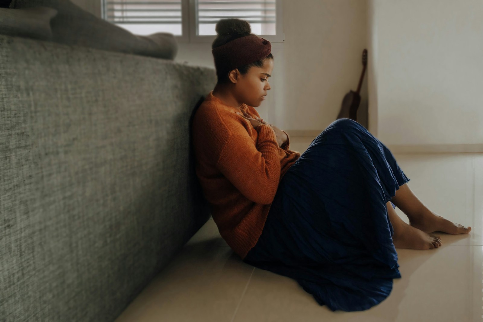 man in orange long sleeve shirt sitting on gray couch situational anxiety