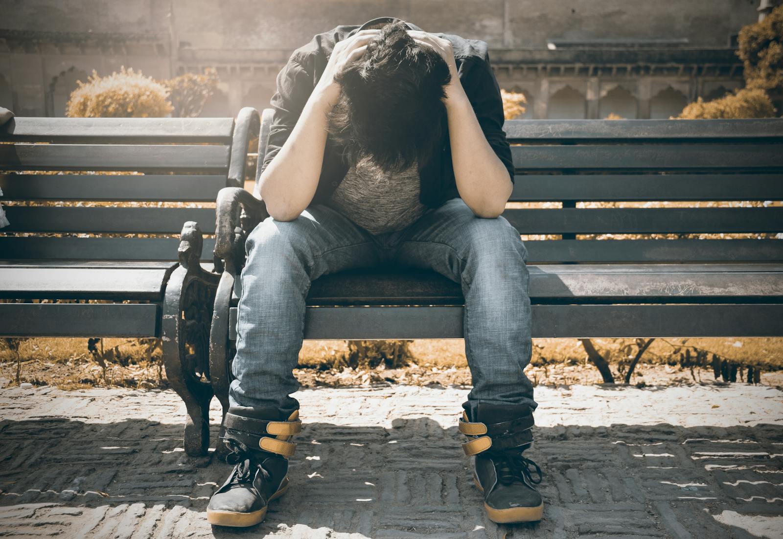 Man sitting alone on a bench in Agra, displaying signs of stress and loneliness. serious mental illness