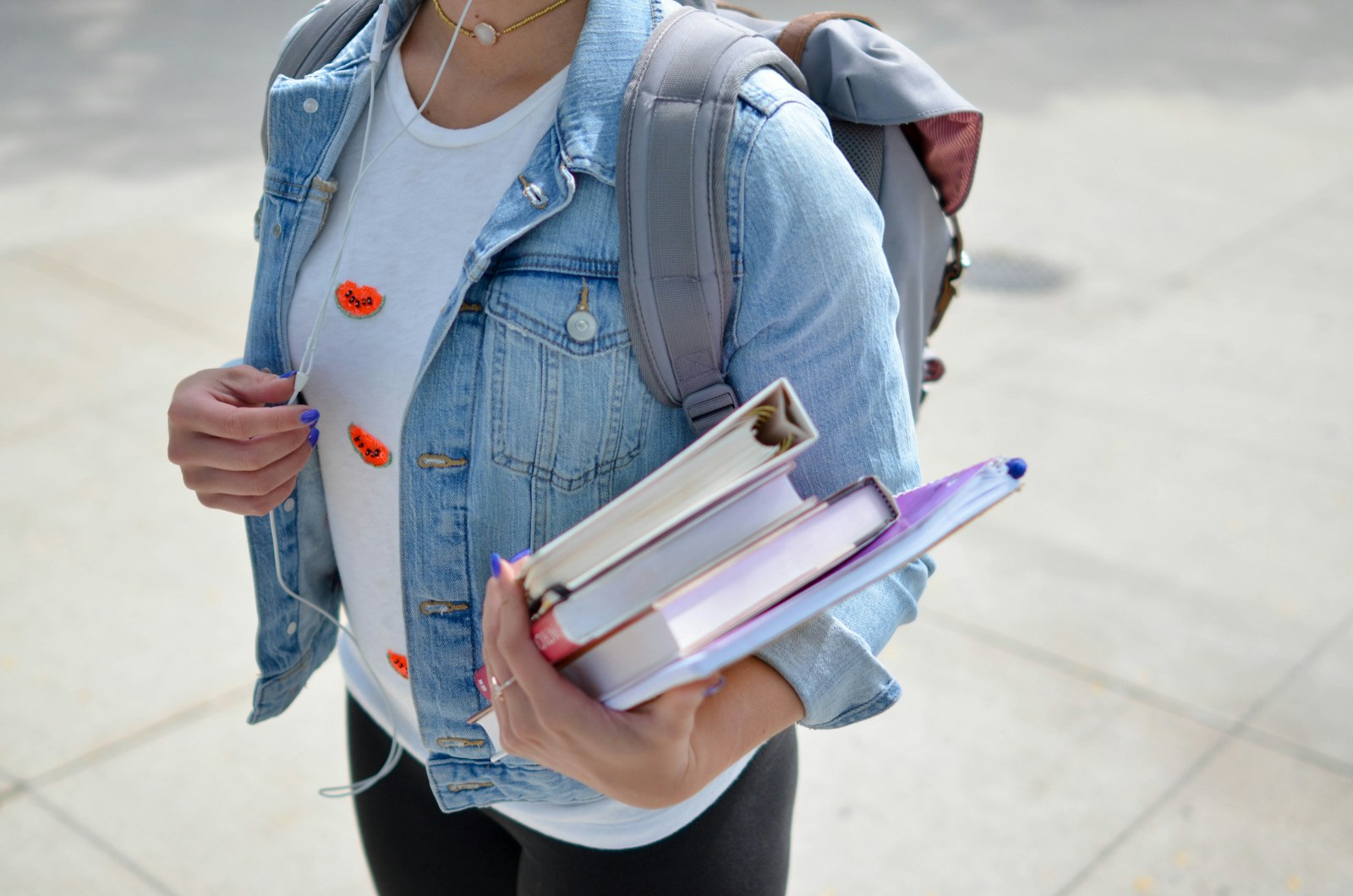 woman wearing blue denim jacket holding book mental health in schools