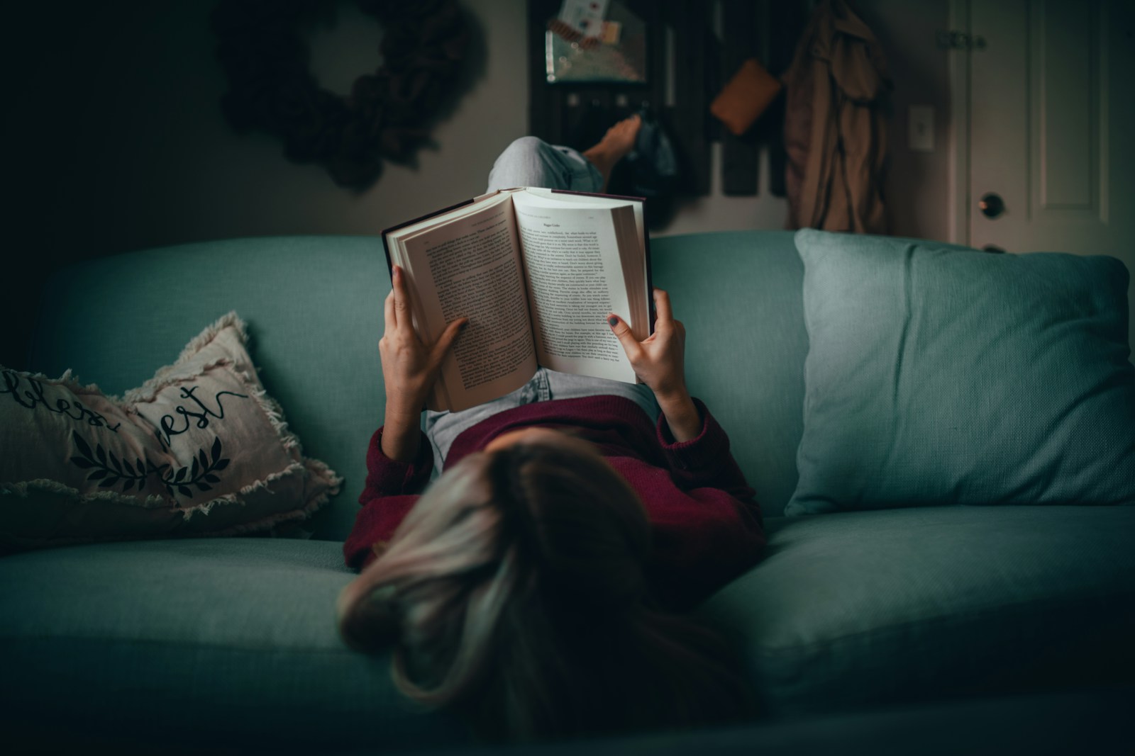woman in red shirt reading book mental health books