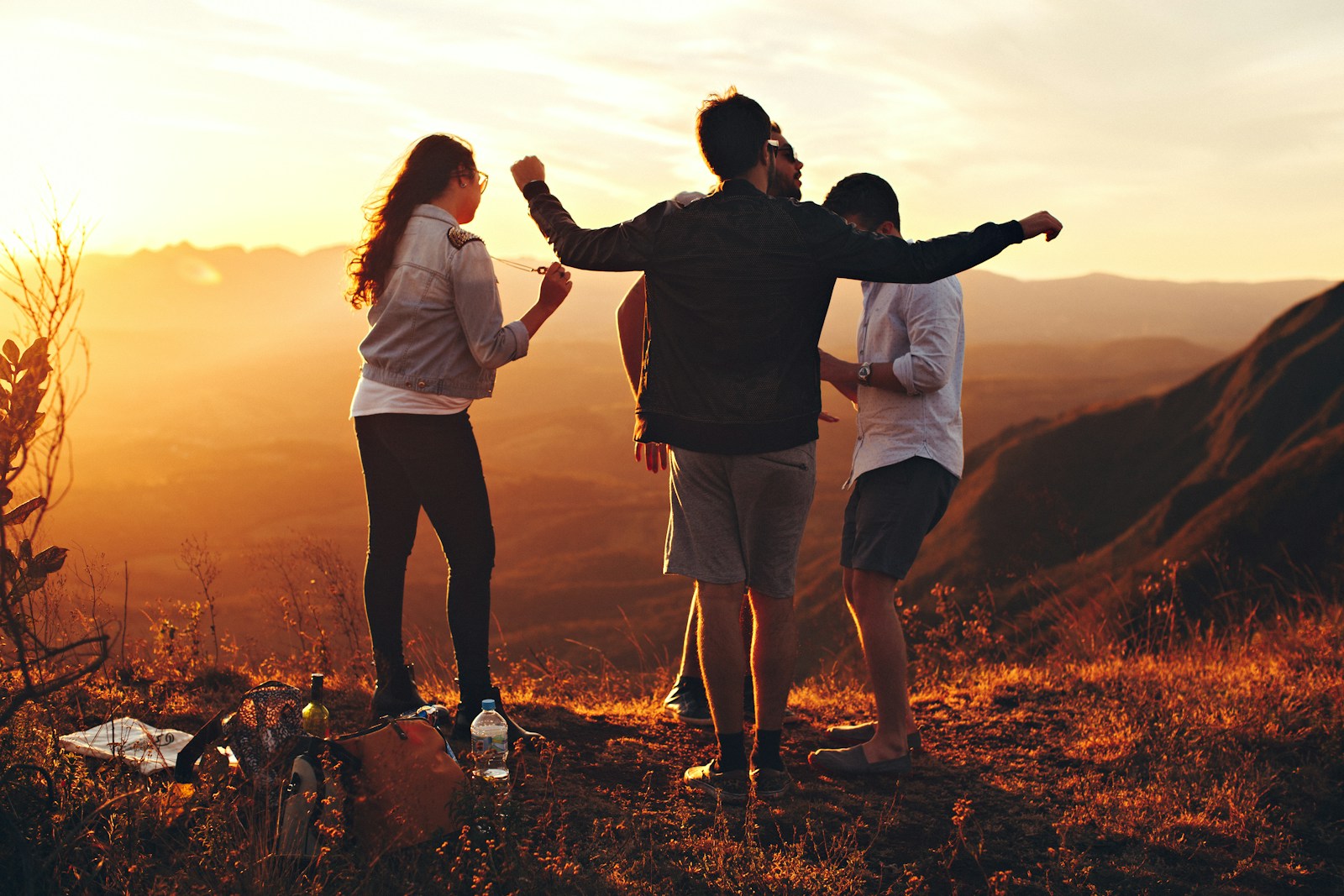 four people standing on edge of mountain adultism