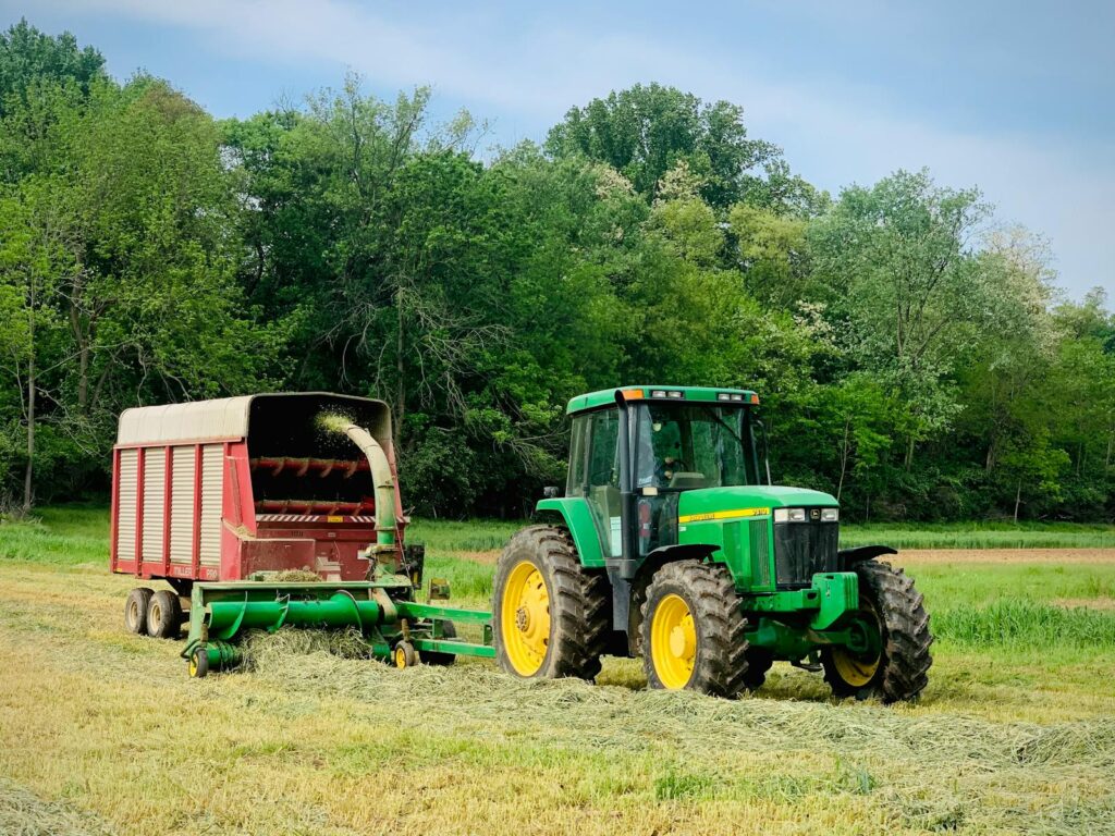 A green tractor with a hay wagon in Lancaster, PA during summer. Ideal for agricultural themes.
