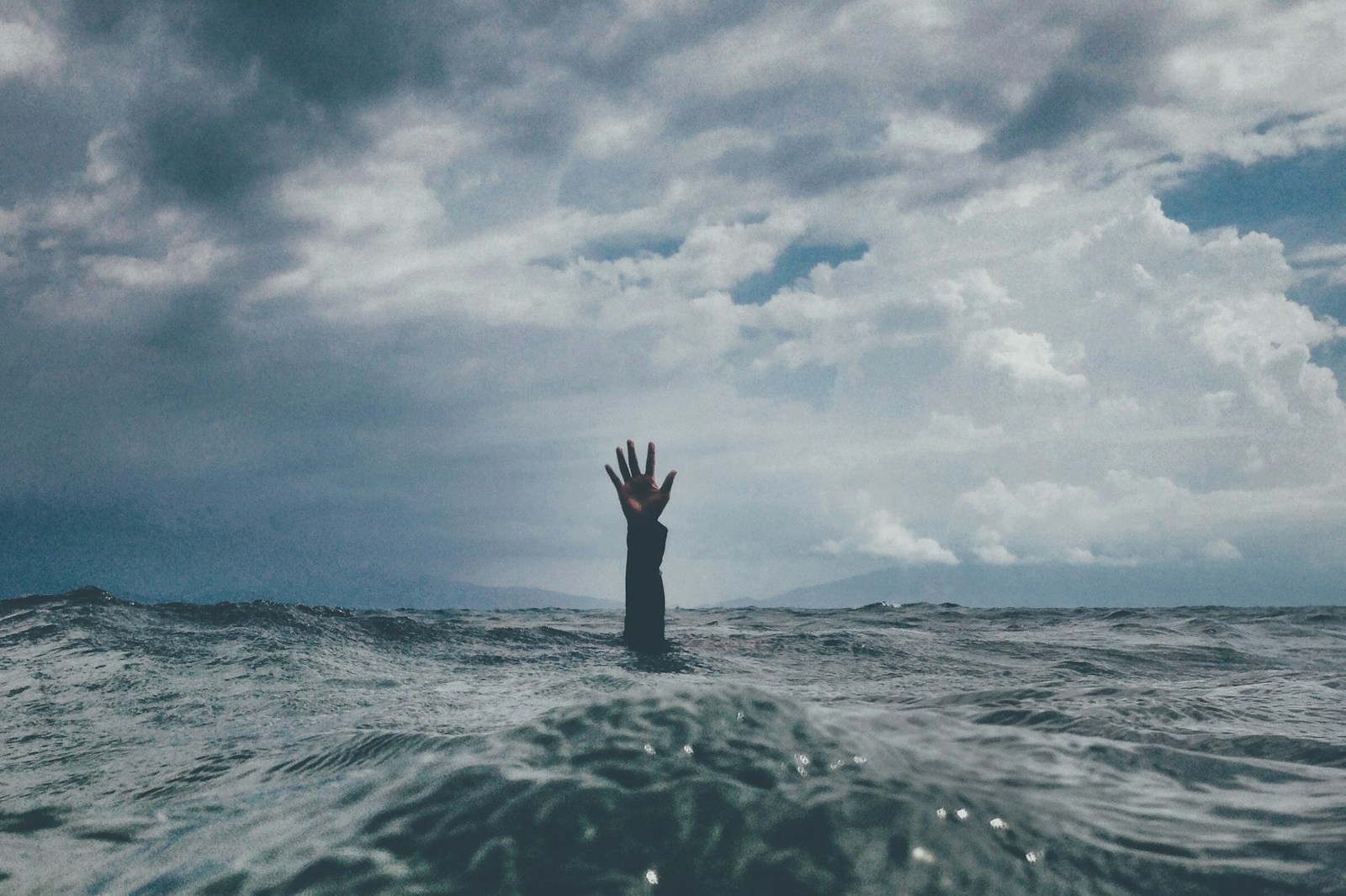 photo of person reach out above the water stress