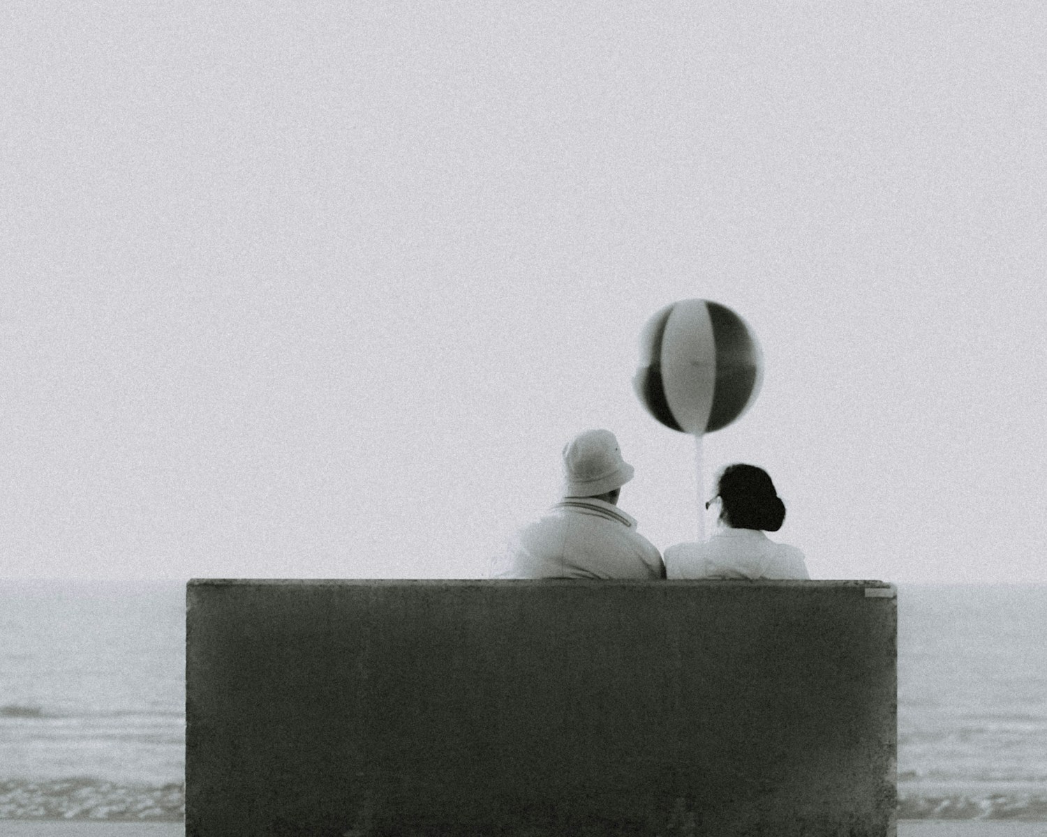 couple sitting on bench in front of beach Existential Crisis