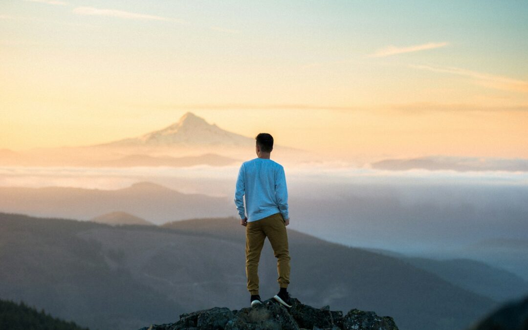 man standing on top of mountain Strength-Based Therapy
