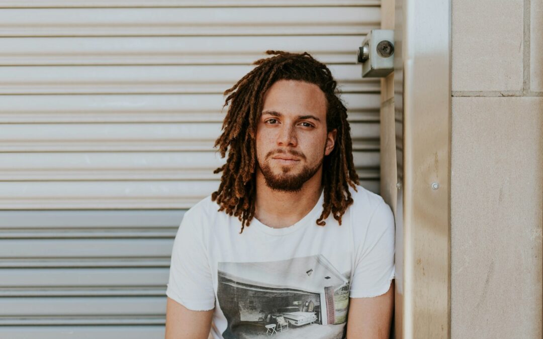 man sitting near gray steel roller shutters during daytime Relational Therapy