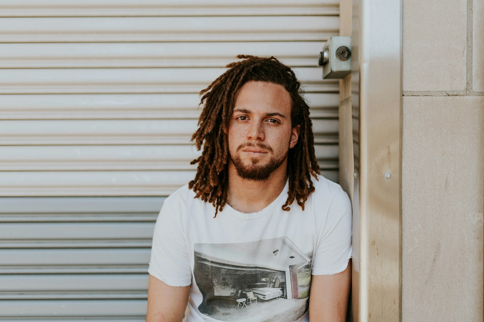 man sitting near gray steel roller shutters during daytime Relational Therapy