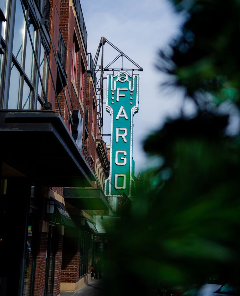 a large green sign hanging from the side of a building