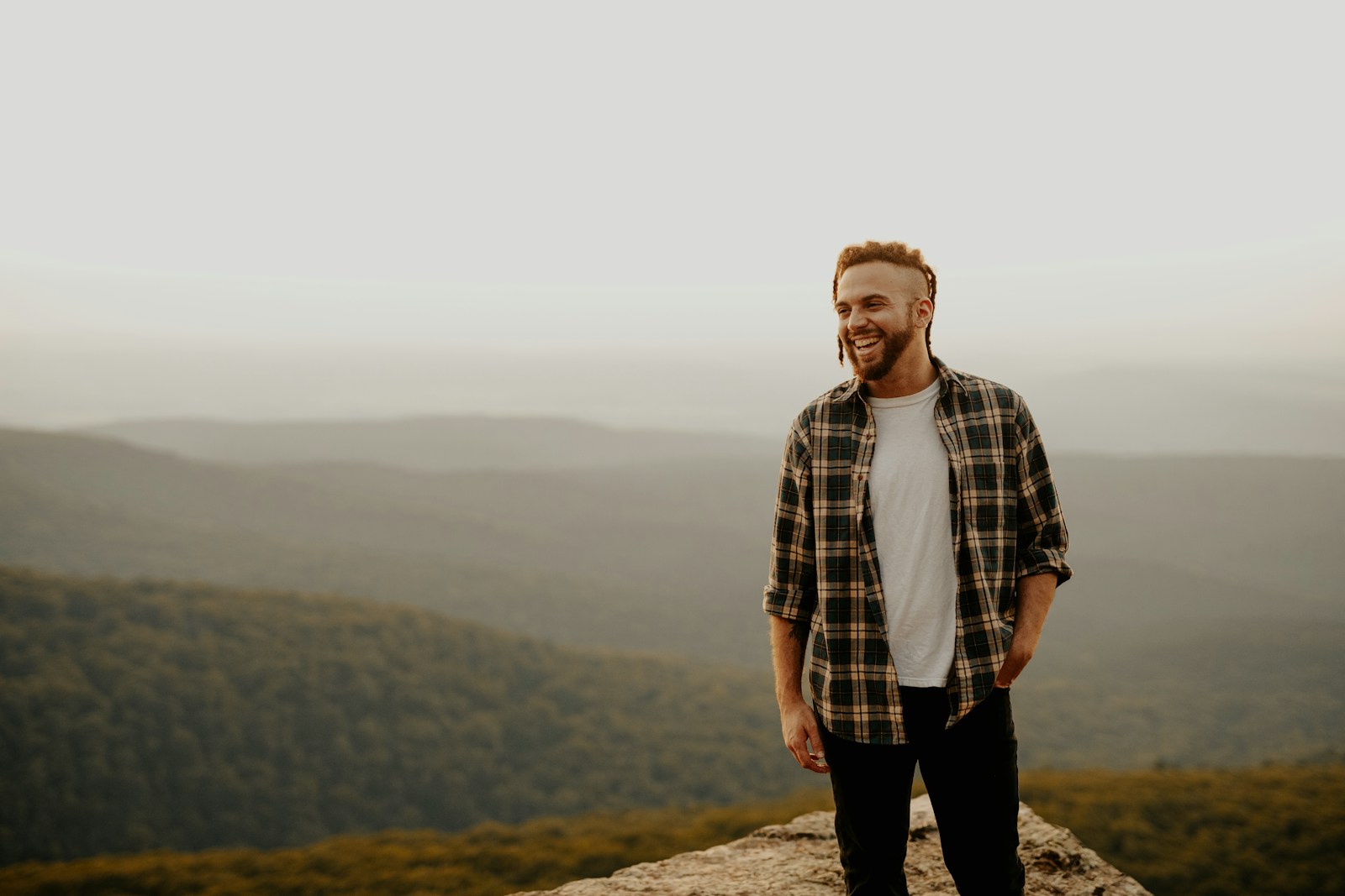 man in brown and white plaid button up shirt standing on brown rock during daytime Existential Therapy