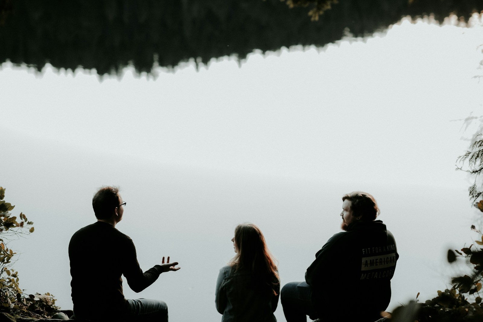 silhouette of three people sitting on cliff under foggy weather Trauma Therapy