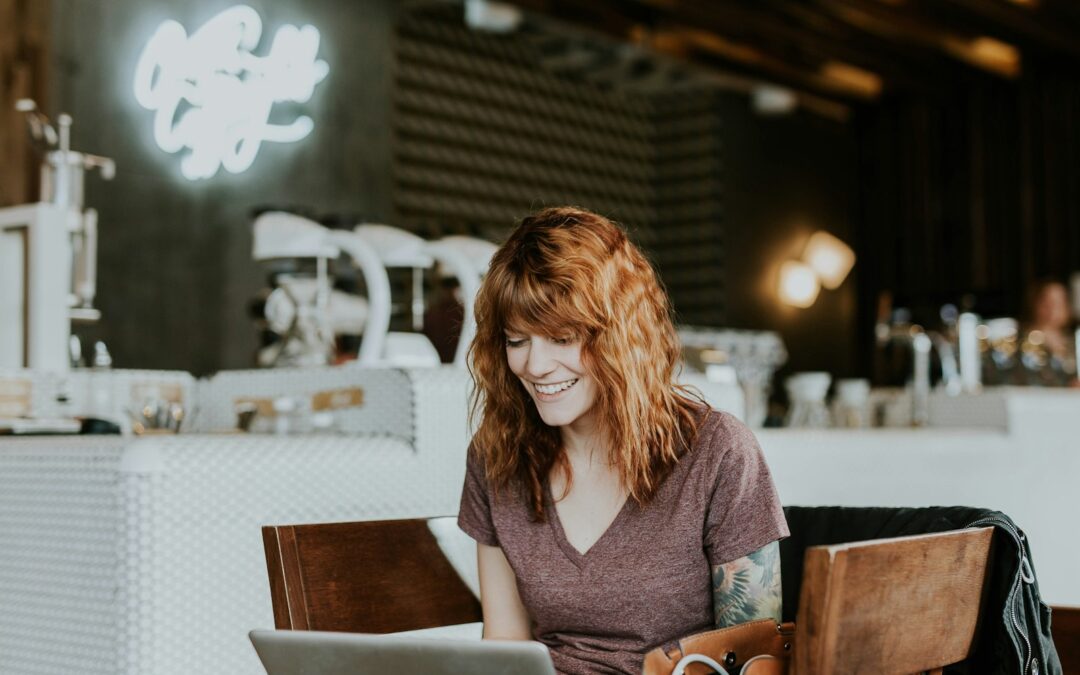 woman sitting on brown wooden chair while using silver laptop computer in room Trauma Resiliency Model