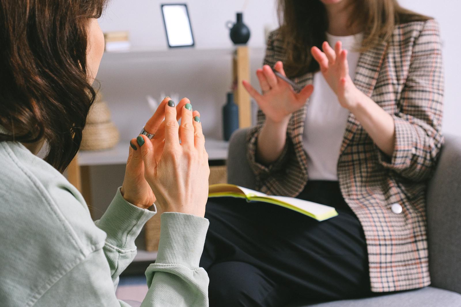 Two women engaged in a therapy session, communication and support in an office setting. (CBT Exercises) vs DBT Exercises: What’s the Difference?