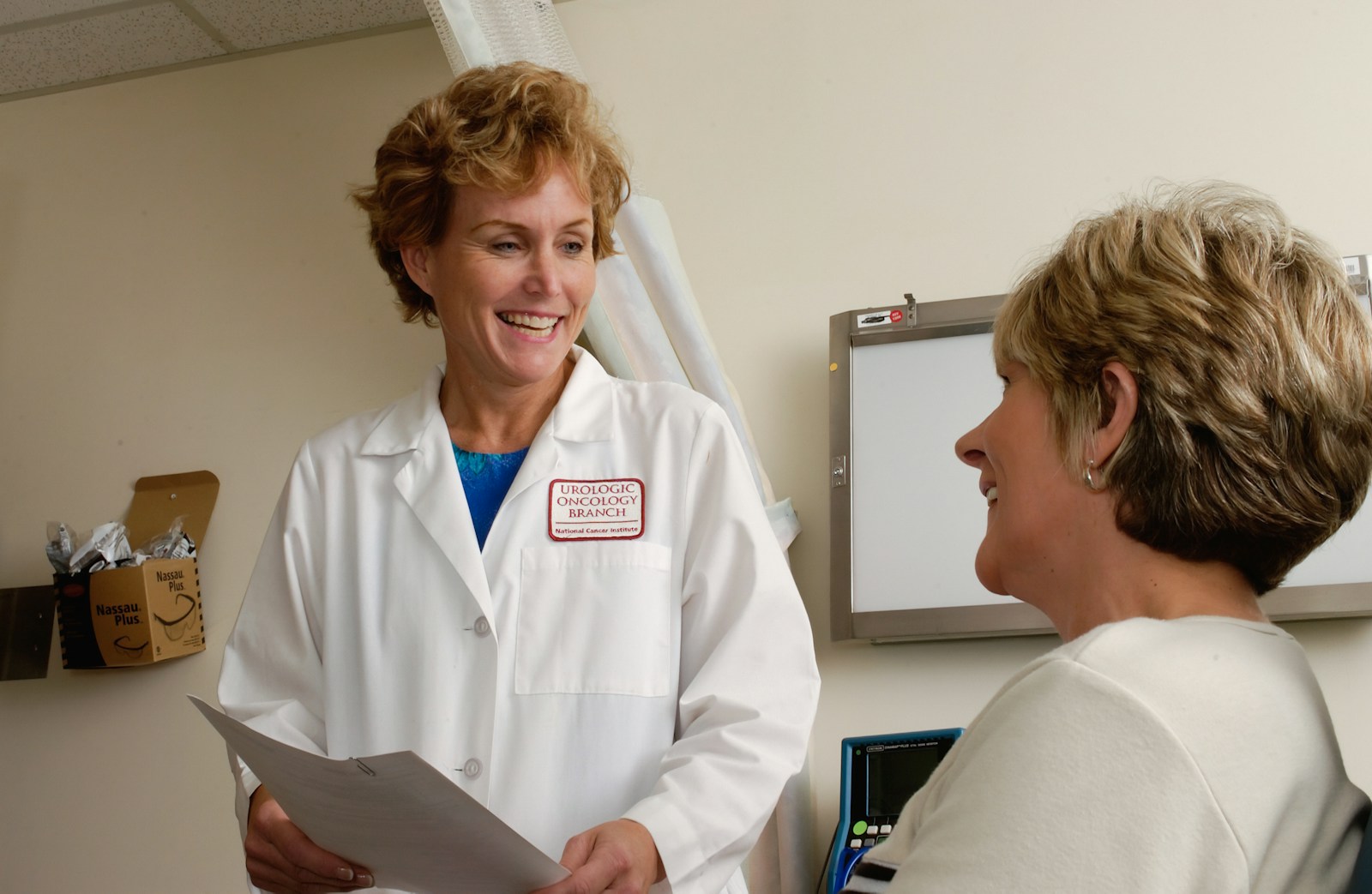 woman in white scrub suit holding gray laptop computer Medical Trauma: How Repeated Health Experiences Can Affect Mental Health and Trust