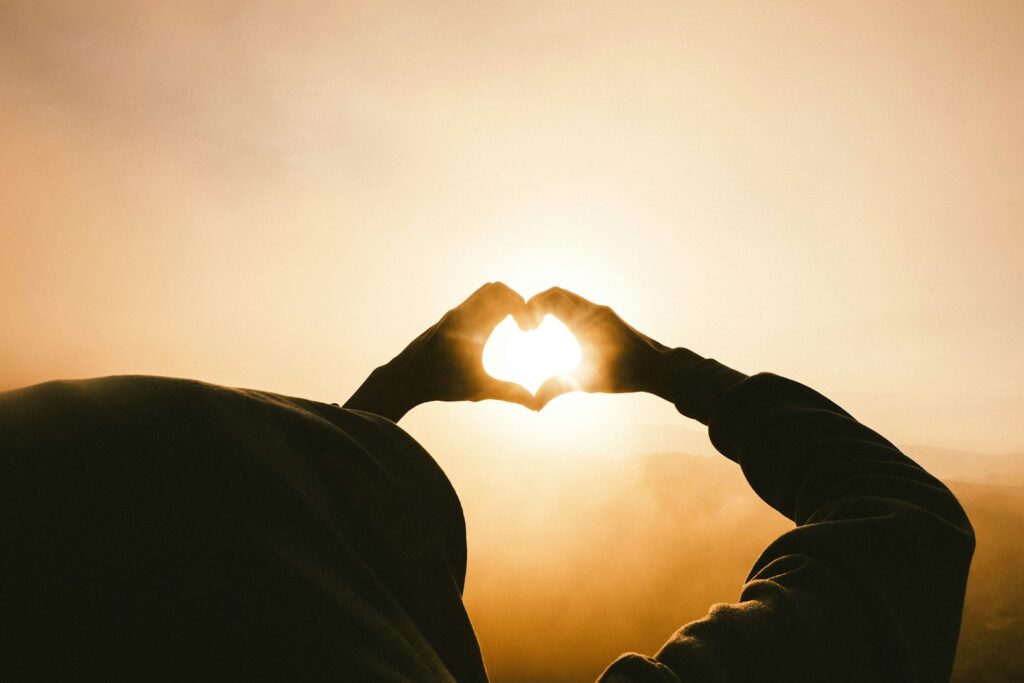 person doing heart shape hand with sun light passing thru Psychotic Depression Explained: When Severe Mental Health Symptoms Appear During Chronic Stress or Illness