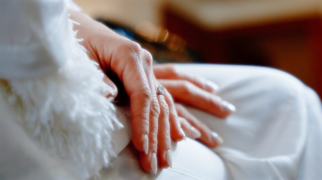a close up of a person's hand on a white chair