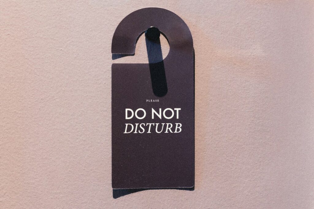 A dark "do not disturb" sign hangs on a wall.