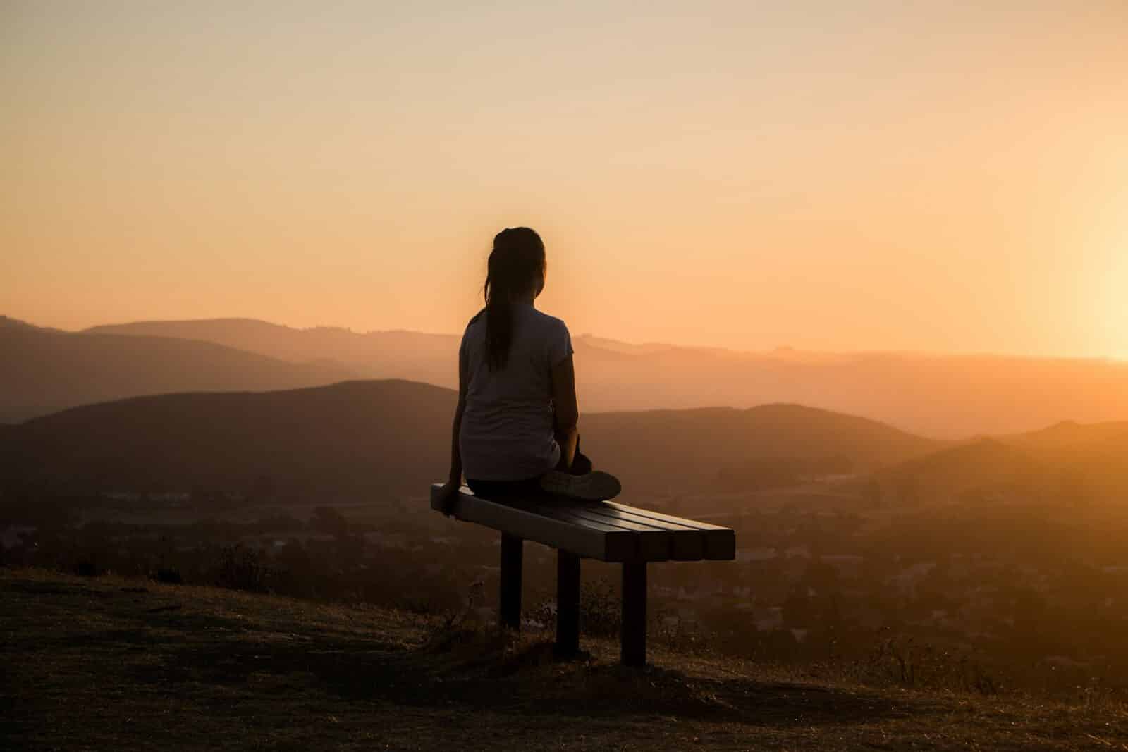 woman sitting on bench over viewing mountain Can Stress Kill You? What Chronic Stress Really Does to the Mind and Body