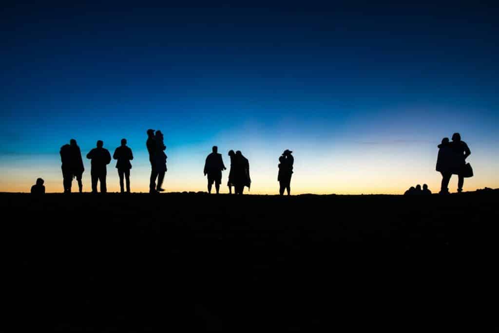 a group of people standing on top of a hill