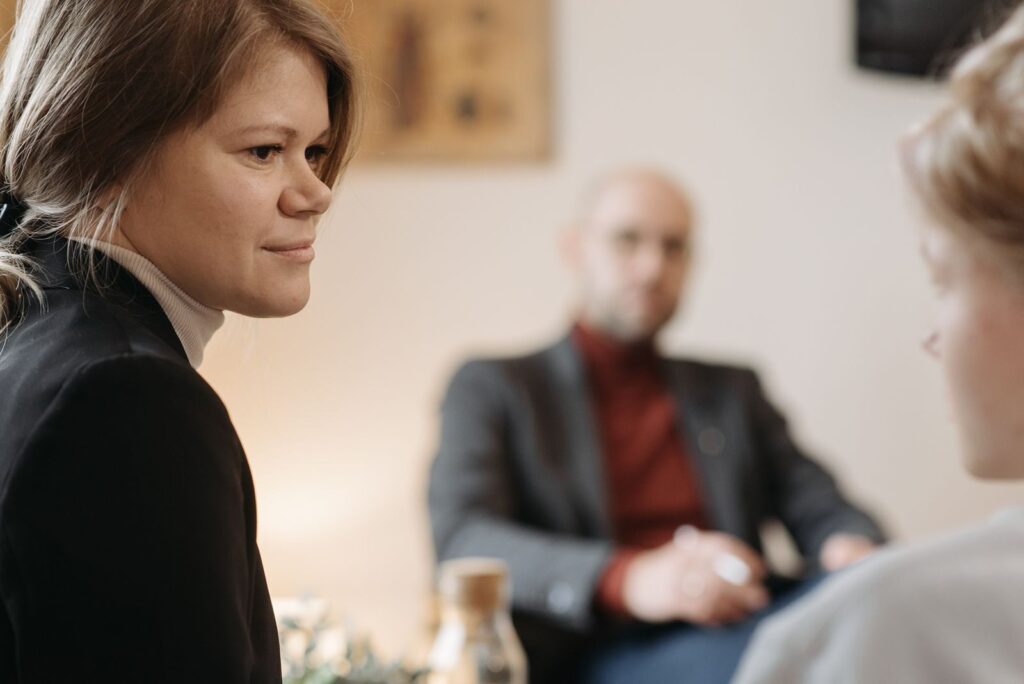 A therapy session in progress with a therapist and two patients in focus.