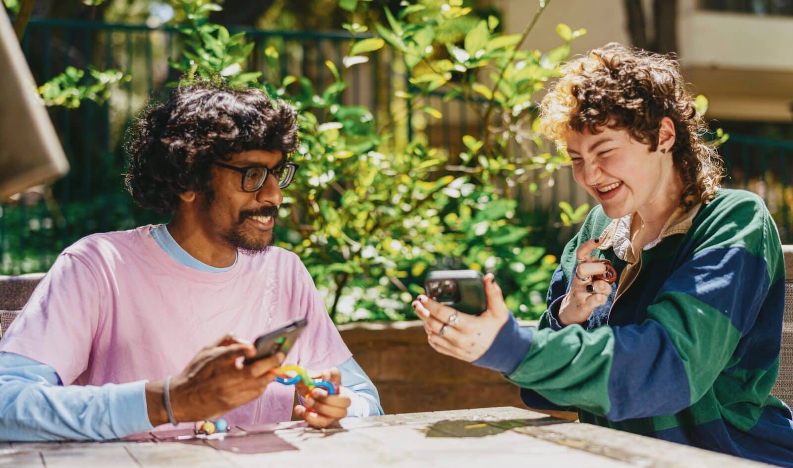Photo by Hiki App Two autistic friends sitting outside using stim toys and laughing at their phones Can You Develop ADHD as an Adult, or Was It Always There?