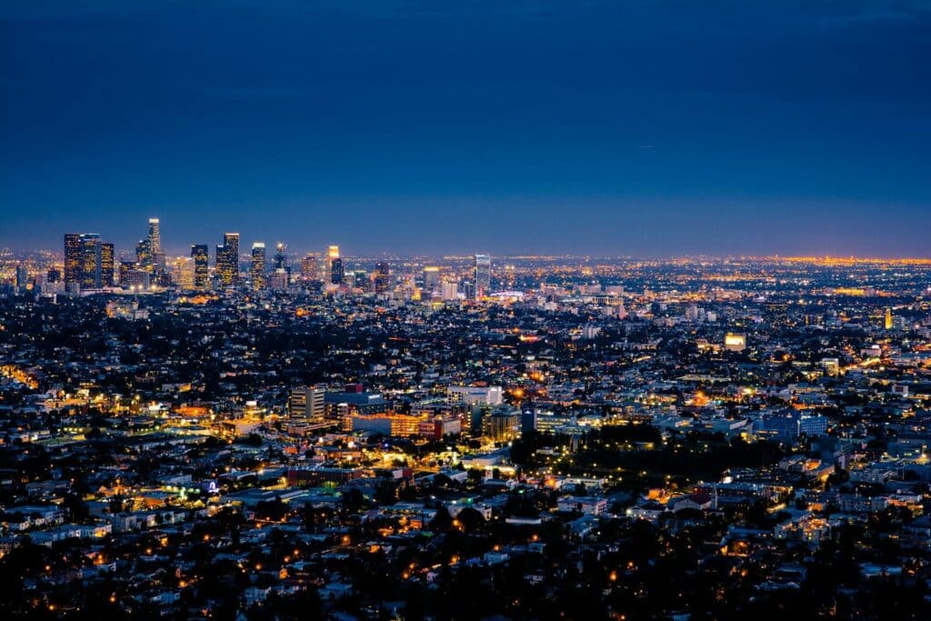 The illuminated skyline of Los Angeles at night under a deep blue sky